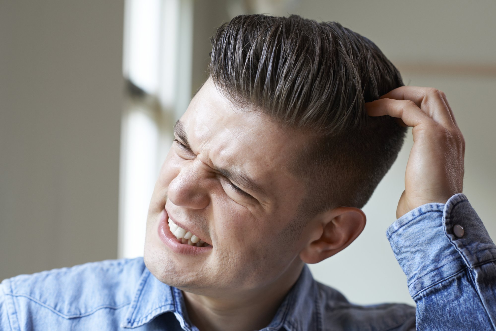 Shot Of Young Man Itching Scalp