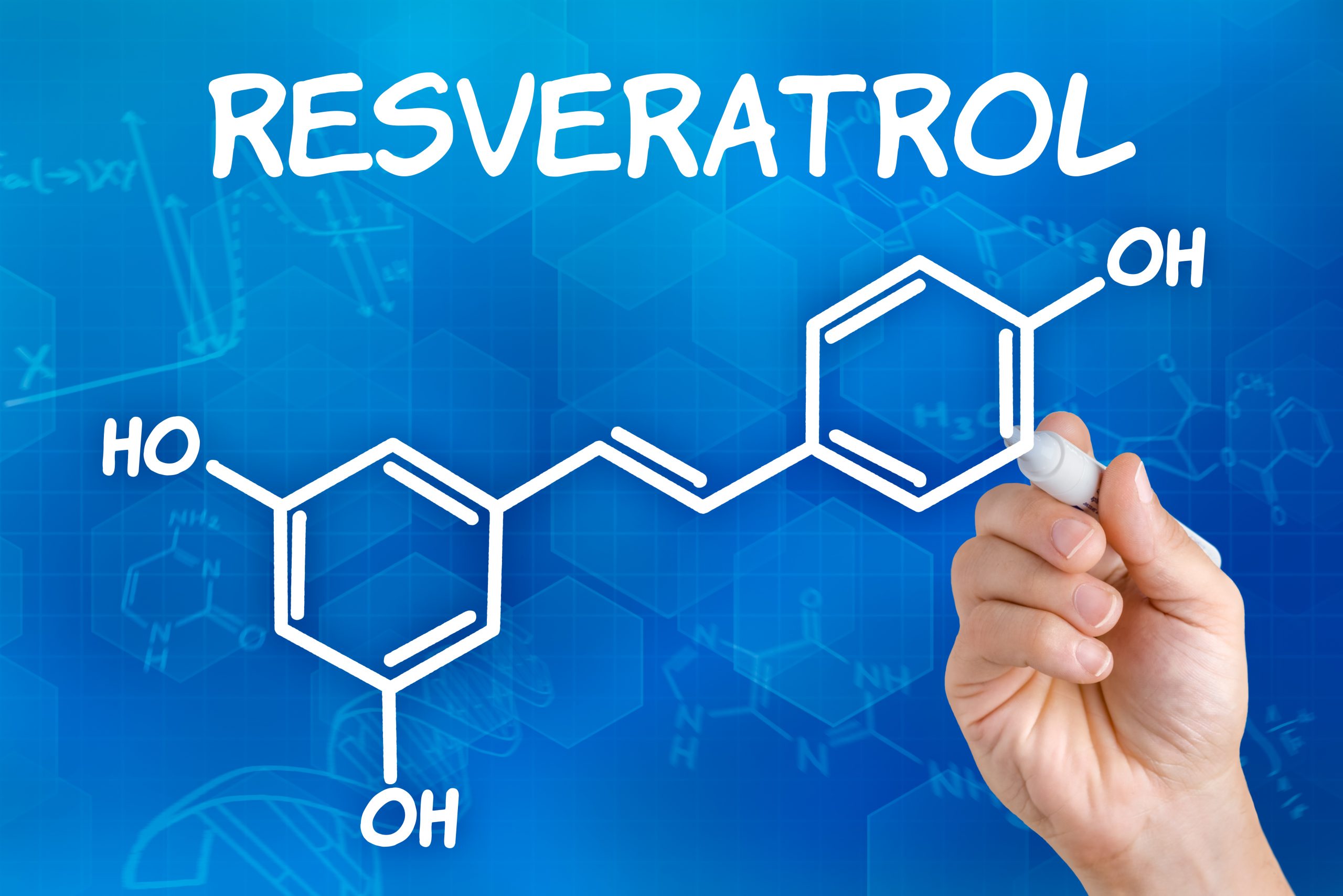 Hand with pen drawing the chemical formula of resveratrol
