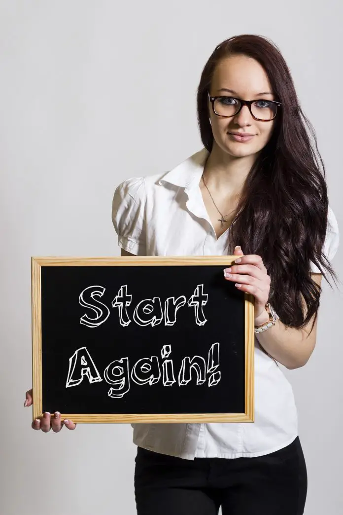 Start Again! - Young businesswoman holding chalkboard